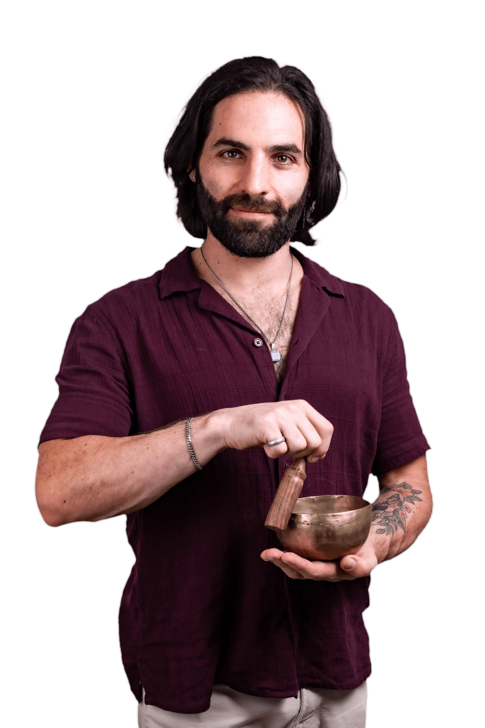 Joseph Buchoff in an oxblood shirt, ringing a brass singing bowl with a calm grin